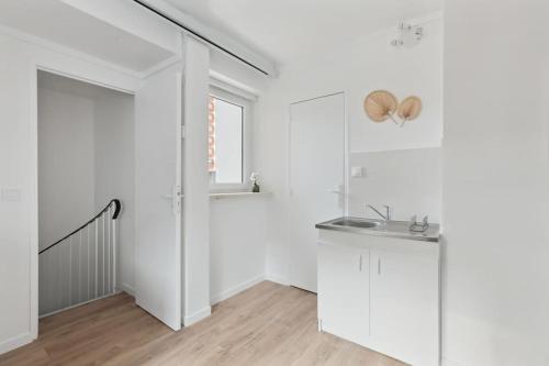 une cuisine blanche avec un évier et une fenêtre dans l'établissement ID 412 - Cozy studio Near Eifel Tower, à Paris