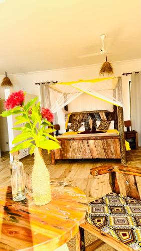 a living room with a table and a bed at Z-Breeze Zanzibar in Kiwengwa