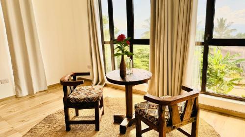 a room with a table and two chairs and a window at Z-Breeze Zanzibar in Kiwengwa