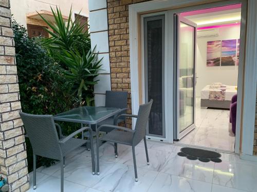 a glass table and chairs on a patio at Alrose in Limenaria