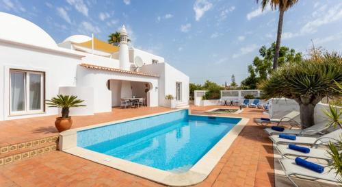 a villa with a swimming pool in front of a house at Casa Cinco Cupulas in Armação de Pêra