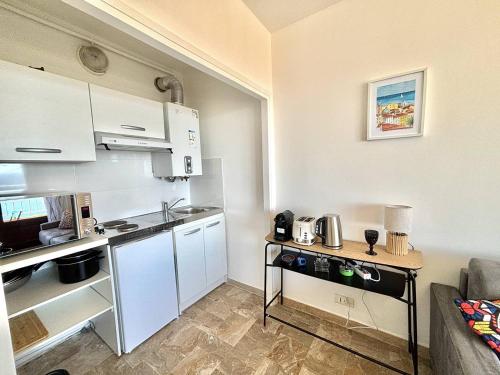 - une petite cuisine avec des placards blancs et un comptoir dans l'établissement Appartement studio Hélios Ajaccio sanguinaires, à Ajaccio