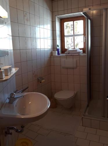 a bathroom with a sink and a toilet and a window at Lärchenhof in Maria Alm am Steinernen Meer