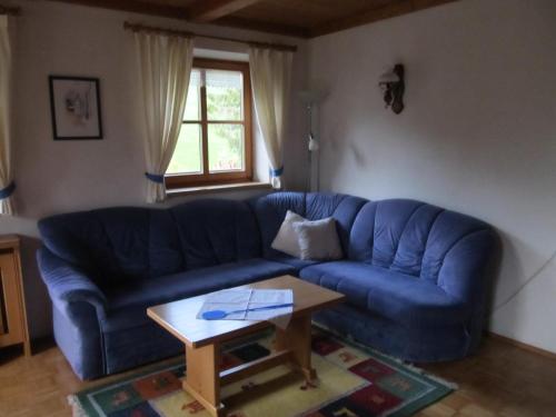 a blue couch in a living room with a coffee table at Lärchenhof in Maria Alm am Steinernen Meer
