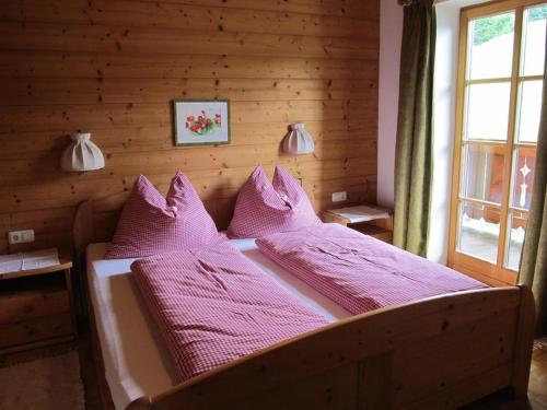 a bedroom with a bed with pink sheets and pillows at Lärchenhof in Maria Alm am Steinernen Meer