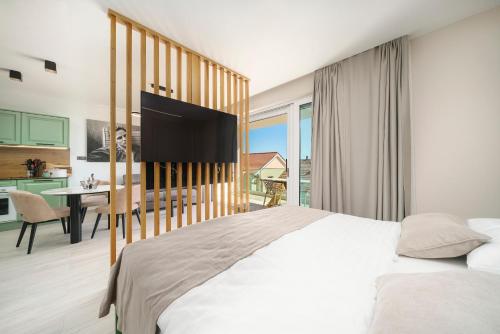 a bedroom with a bed and a desk and a kitchen at Luxury Apartments Maja Vodice in Srima
