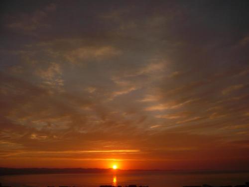 a sunset over the ocean with a cloudy sky at A1 Kynaston Guest House bed and breakfast or self catering in Jeffreys Bay