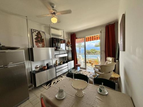 un salon avec une table et une cuisine dans l'établissement Appartement 2 pièces Le Versailles Ajaccio Sanguinaires, à Ajaccio