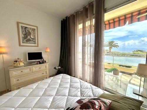 - une chambre avec une grande fenêtre donnant sur l'océan dans l'établissement Appartement 2 pièces Le Versailles Ajaccio Sanguinaires, à Ajaccio