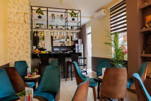 a restaurant with green chairs and a bar at Garni Hotel Biser in Kru&scaron;evac