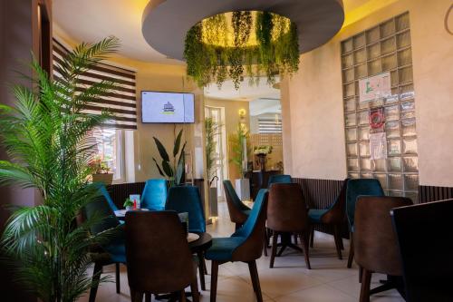 a restaurant with blue chairs and a chandelier at Garni Hotel Biser in Kru&scaron;evac