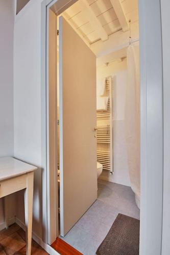 a bathroom with a toilet and a door to a room at Casa Massarelli in San Severino Marche