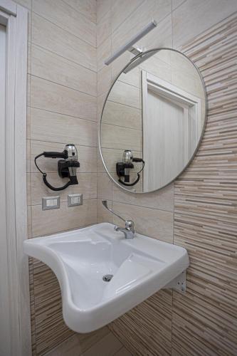 a bathroom with a white sink and a mirror at Monia Rooms&Hospitality in Piazza Armerina