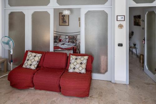 a living room with a red couch with two pillows at Il Ritrovo degli Artisti in Castrovillari