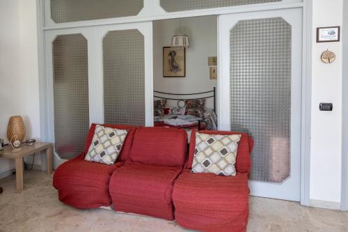a red couch with two pillows in a living room at Il Ritrovo degli Artisti in Castrovillari