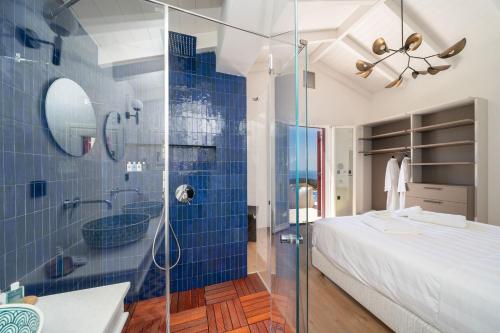 a blue tiled bathroom with a bed and a shower at CASTA DIVA Luxury Accommodation in Fiskardho