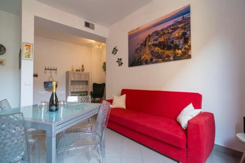a living room with a red couch and a table at AlbaChiara in Alghero
