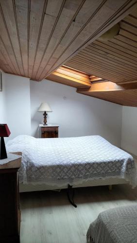 une chambre avec un grand lit avec un plafond en bois dans l'établissement Villa charmante à Sisteron avec piscine privée, à Sisteron
