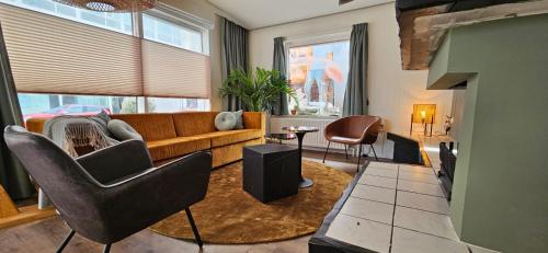 a living room with a couch and chairs at Villa Zeezicht in Noordwijk