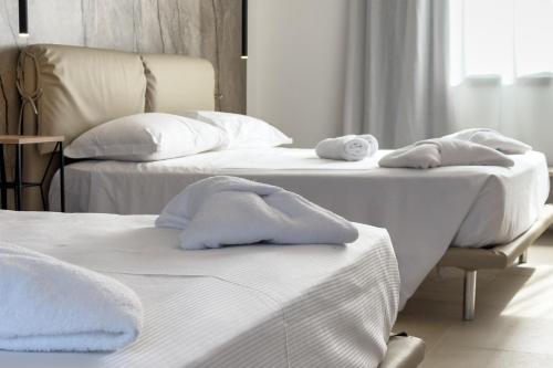two beds with towels on them in a room at Il Crepuscolo Marispica in Santa Maria Del Focallo