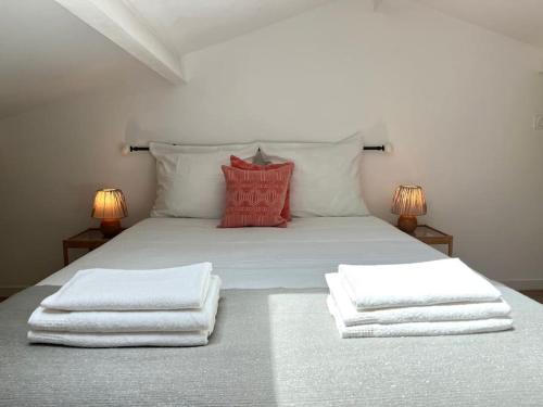 - un lit avec des serviettes blanches et 2 lampes dans l'établissement Appartement à deux pas des plages, à Saint-Cyr-sur-Mer