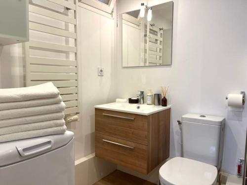 une salle de bain blanche avec des toilettes et un lavabo dans l'établissement Appartement à deux pas des plages, à Saint-Cyr-sur-Mer