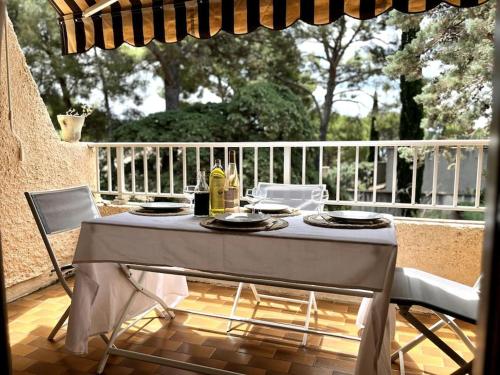 une table blanche et des chaises sur une terrasse dans l'établissement Appartement à deux pas des plages, à Saint-Cyr-sur-Mer