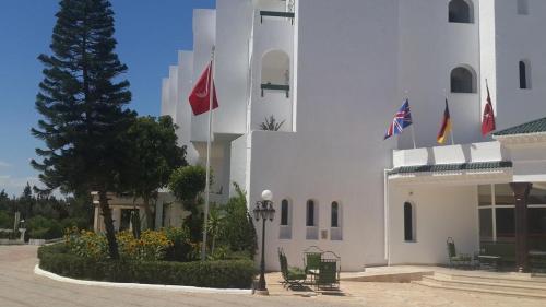 a white building with flags on the side of it at Miramar Sharm El Kantaoui ex Miramar Golf in Port El Kantaoui