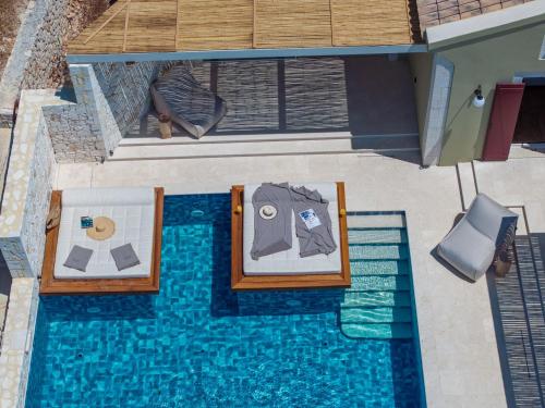 an overhead view of a swimming pool with two beds at CASTA DIVA Luxury Accommodation in Fiskardho
