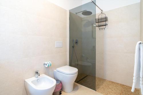 a bathroom with a toilet and a shower and a sink at Il Crepuscolo Marispica in Santa Maria Del Focallo
