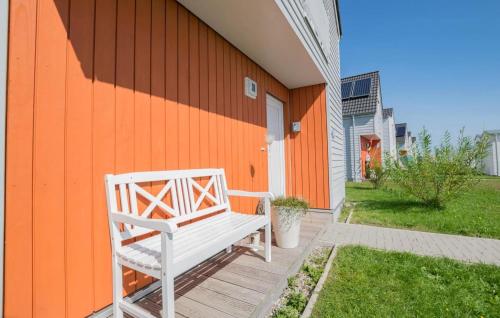 a white bench sitting on the side of a house at Vogelvilla in Olpenitz