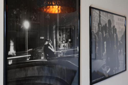 a framed picture of a man sitting at a bar at Virgula Maison in Cuneo