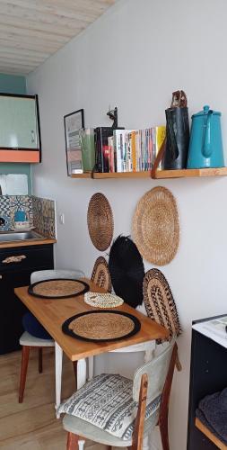 a kitchen with a table with baskets on the wall at COUP DE COEUR Studio in Rivedoux-Plage