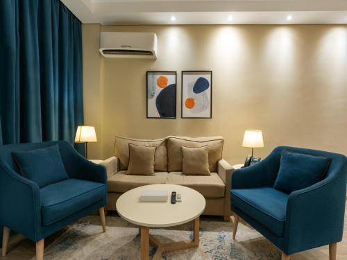 a living room with two blue chairs and a couch at Second Home Hospitality, Rehab City, New Cairo, Cairo Egypt in New cairo