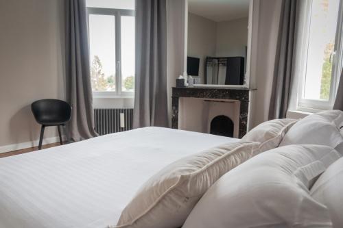 a white bed in a bedroom with a fireplace at Aura Castle in Picquigny