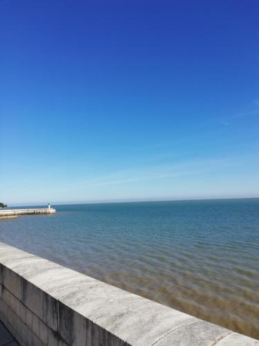 a large body of water with a pier in the background at COUP DE COEUR Studio in Rivedoux-Plage