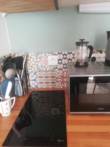 a microwave sitting on a counter next to a stove at COUP DE COEUR Studio in Rivedoux-Plage