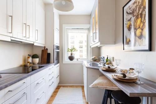 a kitchen with white cabinets and a wooden table at Popular area, central, 55m2, 1-4 guests in Oslo