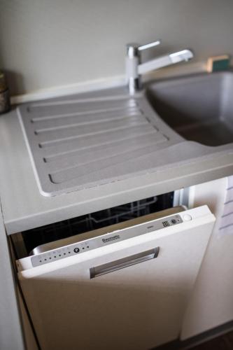 a kitchen counter with a sink and a dishwasher at Fatrapark 2 apartment 214 in Hrabovo with bike storage in Ružomberok