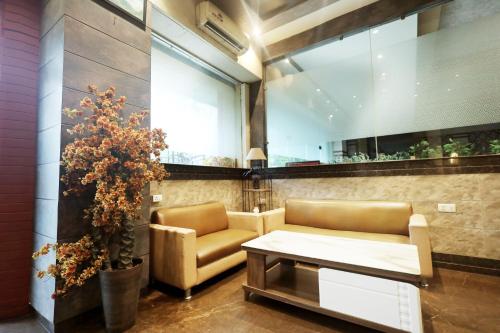 a lobby with a couch and a table and a plant at Hotel Bhagyaraj Palace - Best Hotel In Kanpur in Kānpur