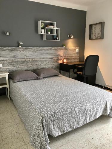 une chambre avec un grand lit et un bureau dans l'établissement A 15mn des plages, beau duplex à Perpignan, à Perpignan