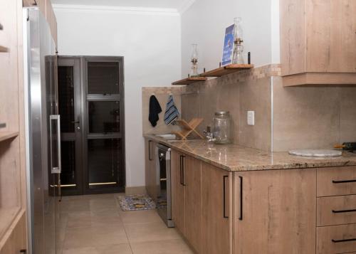 a kitchen with wooden cabinets and a counter top at Seemeeu, Gouritsmond in Gouritzmond