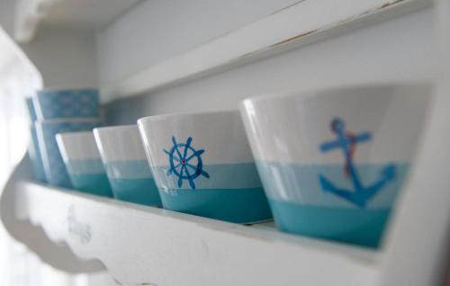 a shelf with blue and white cups on it at Blaue Ferne in Olpenitz
