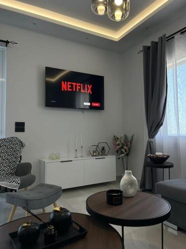 a living room with a television on the wall at Seafront house with private beach in South Crete in Heraklion