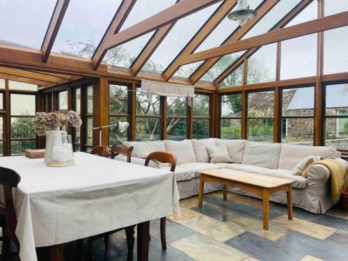 a living room with a white couch in a conservatory at Lower South Hill A Special Country House Near The Sea in Talbenny