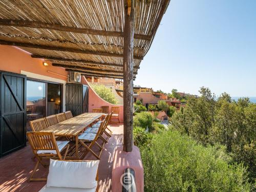 une terrasse avec une table et des chaises en bois. dans l'établissement Blue Eden Vista, à Domus de Maria