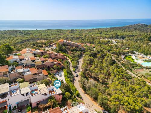 - une vue aérienne sur une petite ville avec des maisons et l'océan dans l'établissement Blue Eden Vista, à Domus de Maria