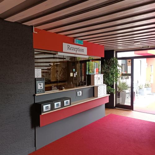 a restaurant with a red and white counter in a building at Hotel Hasselberg in Kaiserslautern