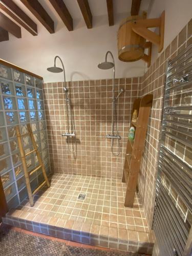 La salle de bains est pourvue d'une douche et de carrelage sur le mur. dans l'établissement Charming Normandy House with sauna, apple orchard, short walk to the beach, à Vattetot-sur-Mer