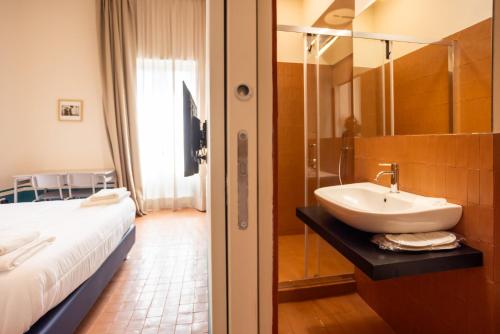 Un baño con lavabo y cama. en Don Vittorio a Chiaia, en Nápoles